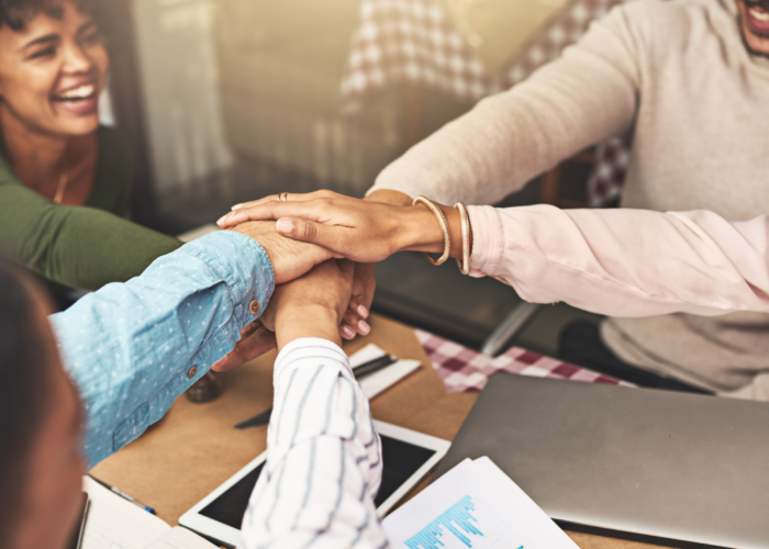 a group of people putting their hands together